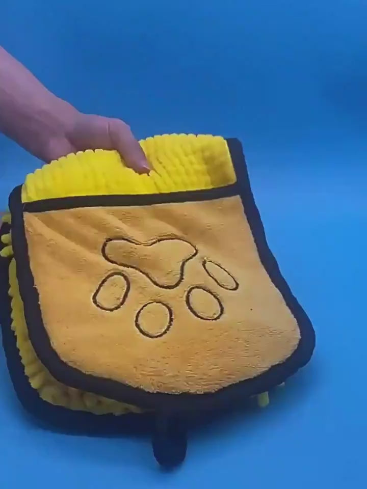 Hands slipping into the towel's pockets to dry a dog