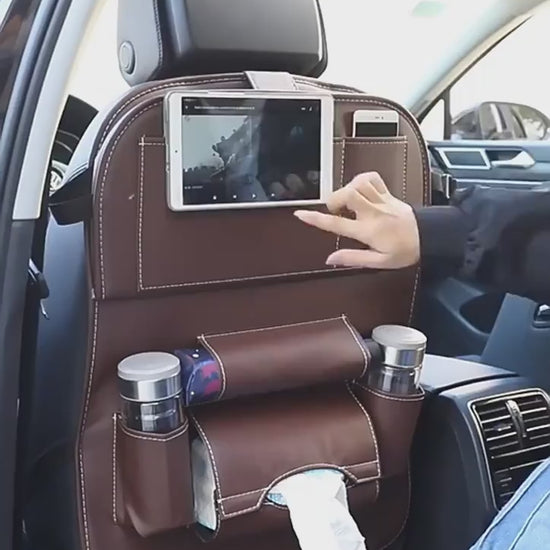 Car seat back organiser in use: tablet holder, fold-down tray and pockets